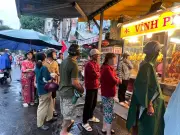 Người dân TPHCM đội mưa xếp hàng mua heo quay, vịt quay cúng Thần tài