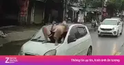 Clip người đàn ông nằm trên capo ô tô đang chạy giữa phố Hà Nội