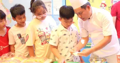 Học sinh xếp hàng làm bánh dân gian cùng thầy hiệu trưởng tại ngày hội văn hóa Việt