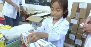 Bé gái phụ mẹ làm thiện nguyện trong chương trình khám bệnh cho trẻ mồ côi
