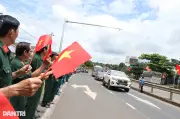 Hàng trăm người cầm cờ Tổ quốc đứng bên đường đón 27 liệt sỹ hồi hương