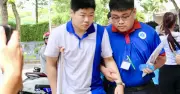 Nam sinh bị chấn thương chân được tình nguyện viên hỗ trợ tận tình trong kỳ thi