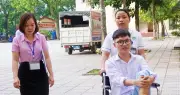 Nhân viên y tế đẩy xe lăn đưa nam sinh đến phòng thi