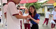 Tình nguyện viên tặng vòng tay may mắn tiếp sức thí sinh